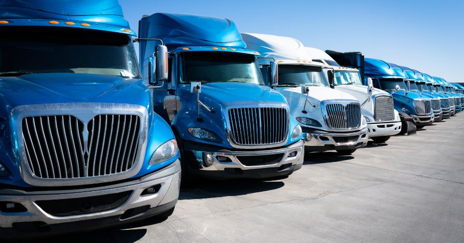 Fleet of blue 18 wheeler semi trucks