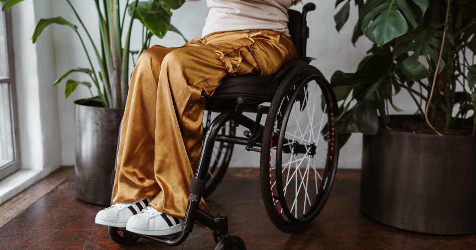 person in brown pants sitting in wheelchair 948x498